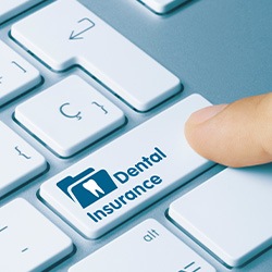 Closeup of finger pressing “dental insurance” button on keyboard