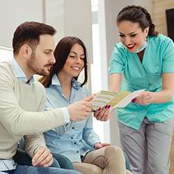 Woman handing payment plan brochure to patients