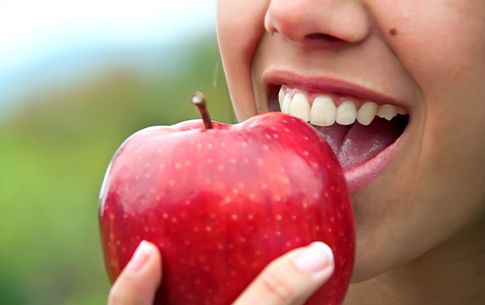 Closeup of person eating a red apple
