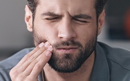 Man in pain holding cheek