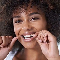 Woman flossing teeth