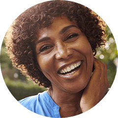 Older woman in blue blouse smiling outdoors