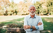 Bearded senior man standing outside and smiling