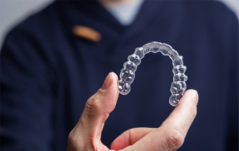 Dentist holding an Invisalign aligner