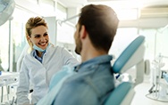 Dentist smiling at patient sitting in treatment chair