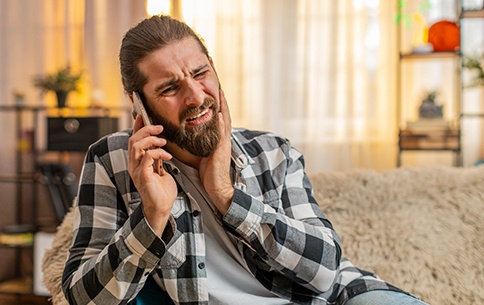 A man with a toothache calling his dentist