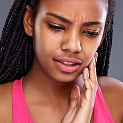 Woman in pain holding cheek