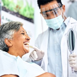 Dentist showing patient their smile in reflection 