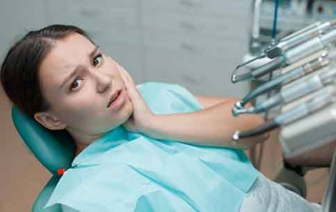 A woman in a dentist’s chair suffering from a toothache