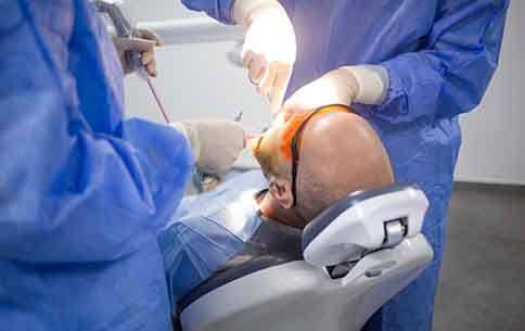 Dentists performing a wisdom tooth extraction surgery