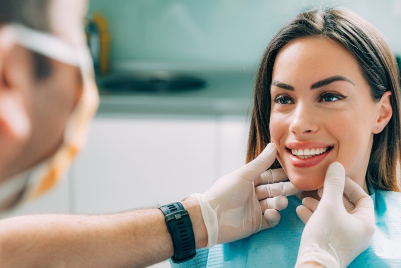 a dentist looking at a female patient’s smile