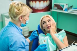 Pained woman with hand on cheek sees her Conway emergency dentist