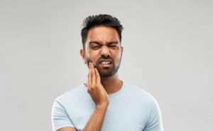 Pained man wondering is a toothache a dental emergency