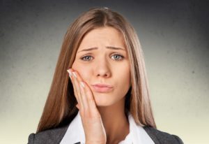 Woman in pain with her hand on her mouth