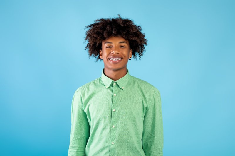 A young man smiling with his orthodontic treatment braces